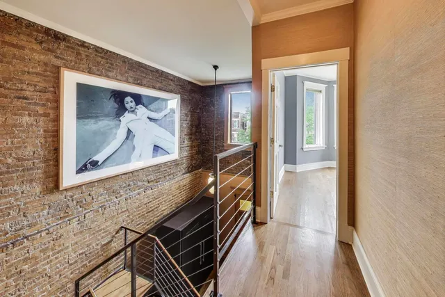 a view of a hallway with wooden floor and staircase