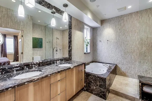 a bathroom with a granite countertop sink a mirror and a toilet