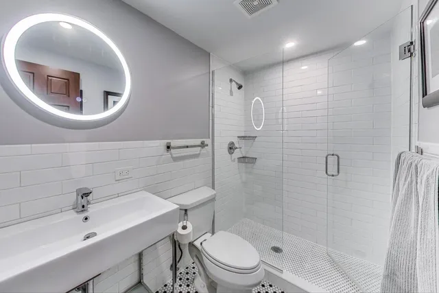 a bathroom with a toilet sink and mirror
