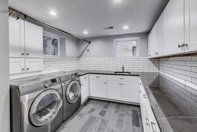 a kitchen with kitchen island granite countertop a sink and a stove top oven