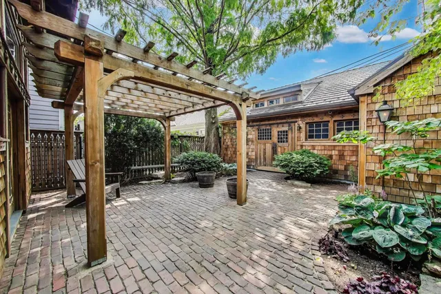 a view of a patio with table and chairs potted plants and floor to ceiling window