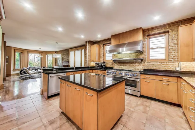 a kitchen with stainless steel appliances granite countertop a sink counter space cabinets and a large window