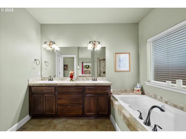 a bathroom with a tub sink shower and mirror