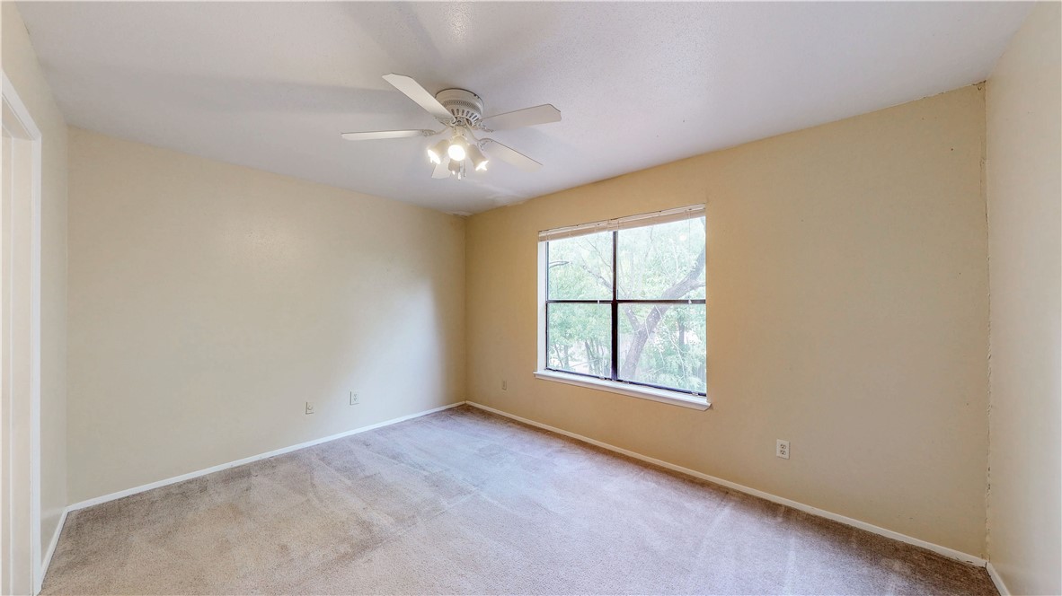301 Manuel Drive, Unit C College Station, TX 77840 - Photo 11 of 25 an empty room with chandelier fan and windows