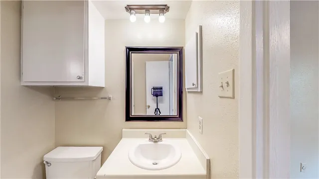 a bathroom with a toilet sink and mirror
