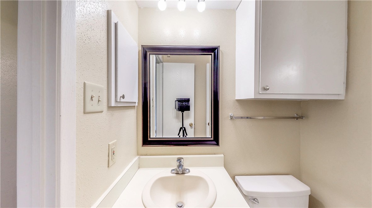 301 Manuel Drive, Unit C College Station, TX 77840 - Photo 18 of 25 a bathroom with a toilet sink and mirror
