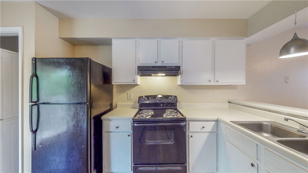 301 Manuel Drive, Unit C College Station, TX 77840 - Photo 6 of 25 a kitchen with a refrigerator sink and cabinets