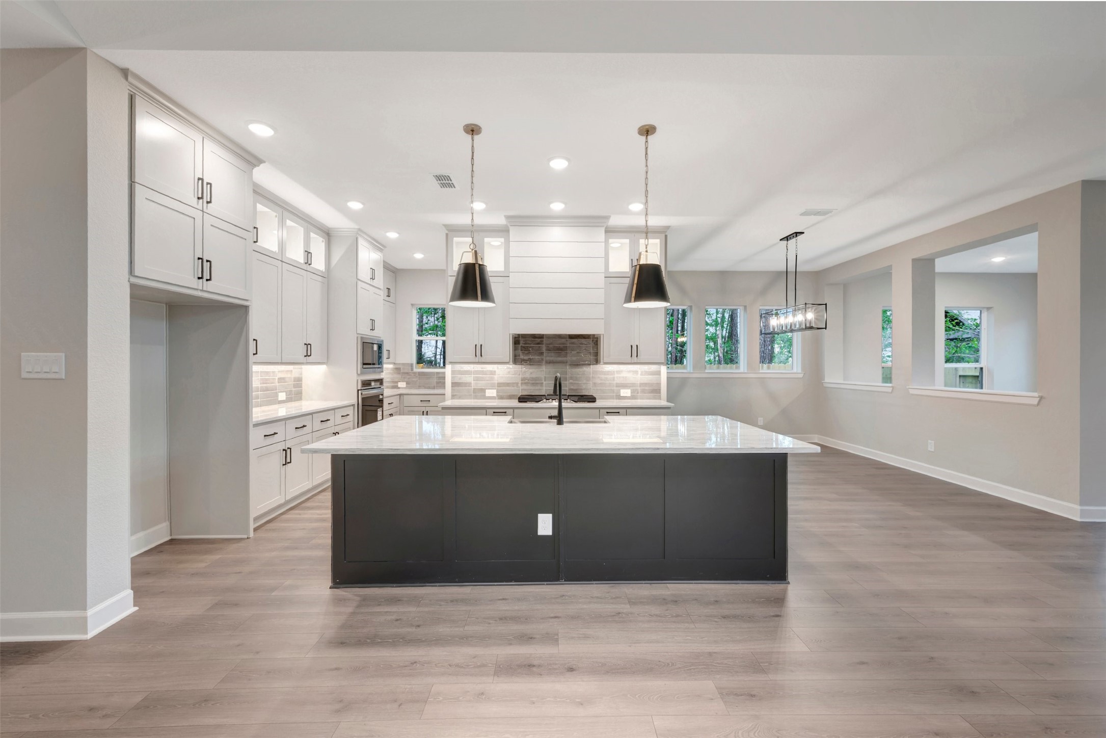 15722 Terracotta Terrace Conroe, TX 77302 - Photo 26 of 50 a view with kitchen island a sink wooden floor and living room view