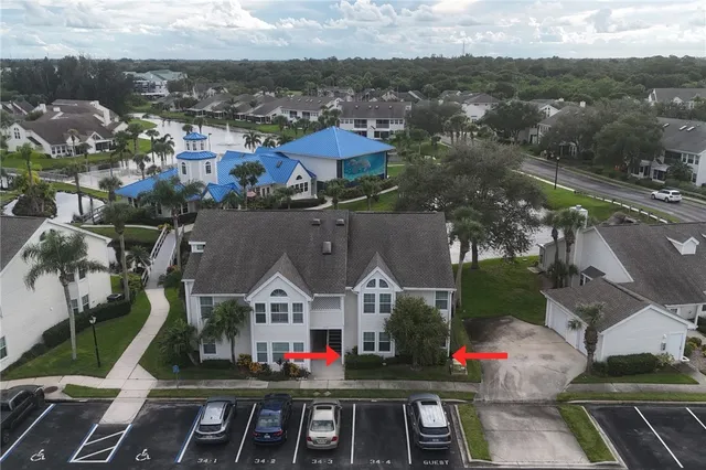 a view of a white house with a small yard and potted plants