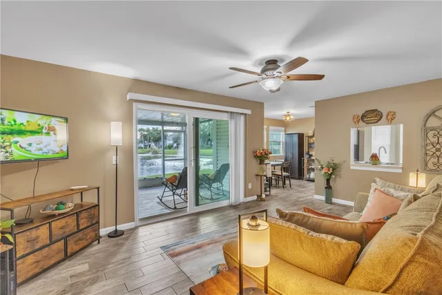 a living room with furniture a flat screen tv and a large window