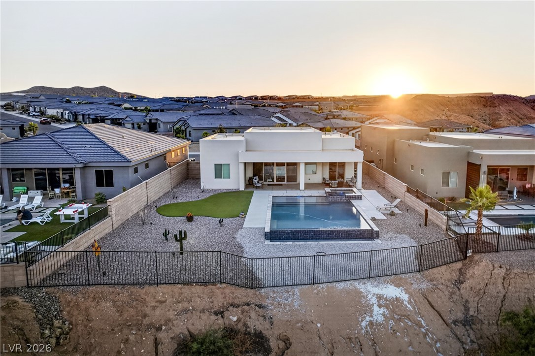 1460 Blue Ridge Trail Mesquite, NV 89027 - Photo 31 of 39 An aerial perspective showcases a sleek modern home, complete with a private pool and desert landscaping, against a backdrop of distant hills.