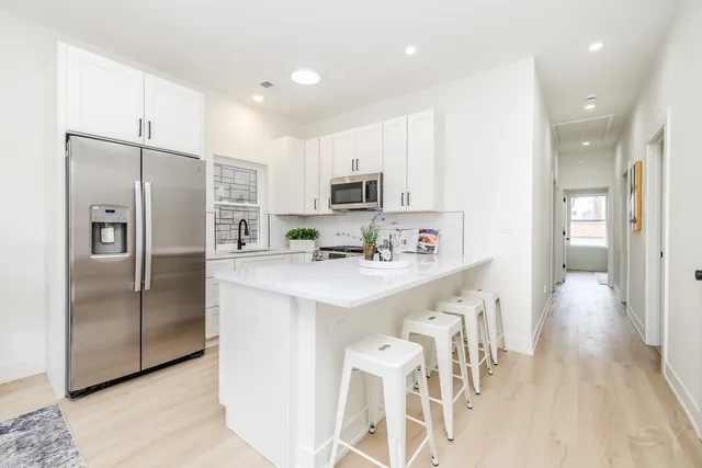 a kitchen with stainless steel appliances a refrigerator sink and microwave