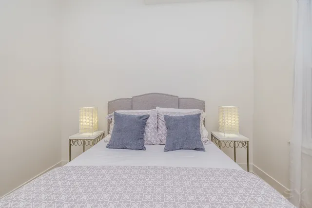 a large bed sitting in a bedroom and a lamp