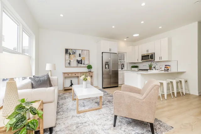 a living room with furniture and a dining table with kitchen view