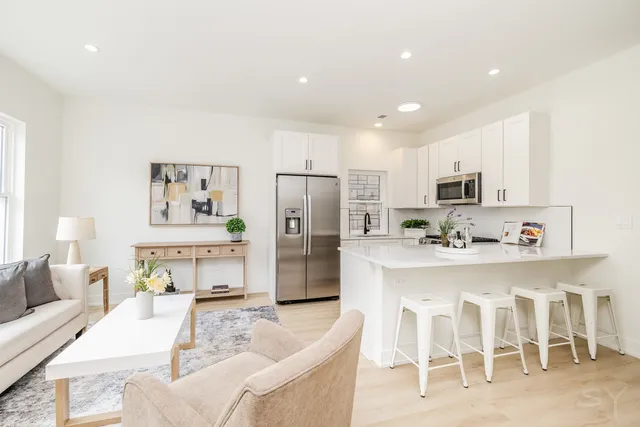 a living room with stainless steel appliances kitchen island granite countertop furniture and a view of kitchen