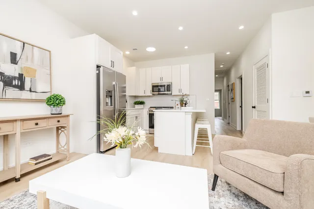 a living room with kitchen island furniture and a refrigerator