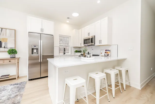 a kitchen with stainless steel appliances a refrigerator sink and microwave