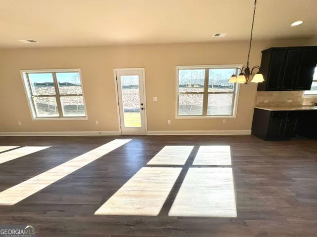 a large kitchen with wooden floor a sink and dishwasher a refrigerator with wooden floors