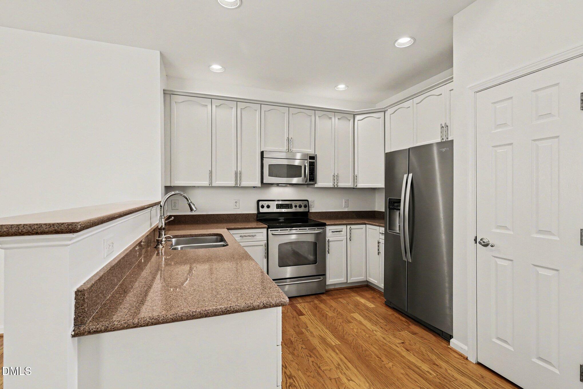 723 Swan Neck Lane Raleigh, NC 27615 - Photo 11 of 52 a kitchen with a refrigerator stove and microwave