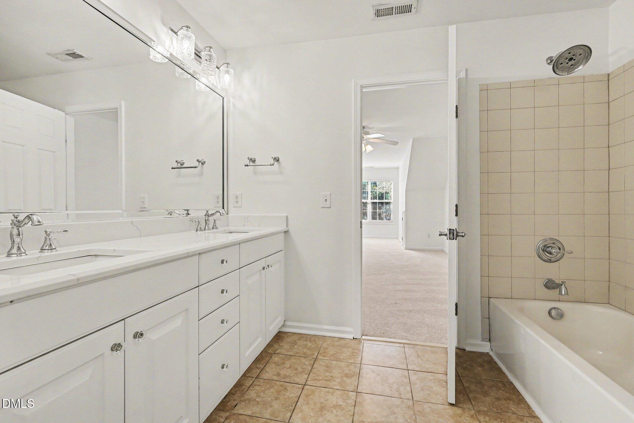 723 Swan Neck Lane Raleigh, NC 27615 - Photo 33 of 52 a bathroom with a tub a sink shower and mirror