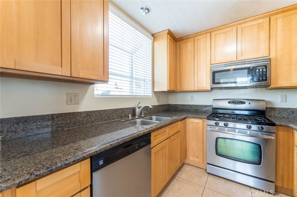 511 East Harvard Road, Unit 101 Burbank, CA 91501 - Photo 12 of 29 a kitchen with granite countertop cabinets stainless steel appliances a sink and window