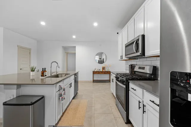 a kitchen with stainless steel appliances granite countertop a sink stove and cabinets