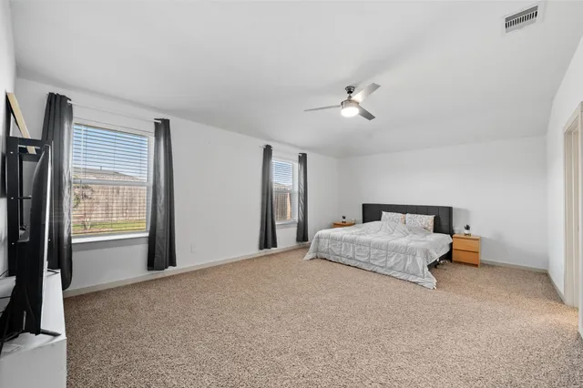a spacious bedroom with a bed and a chandelier