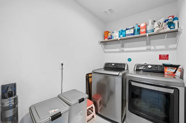 a utility room with dryer washer and empty racks