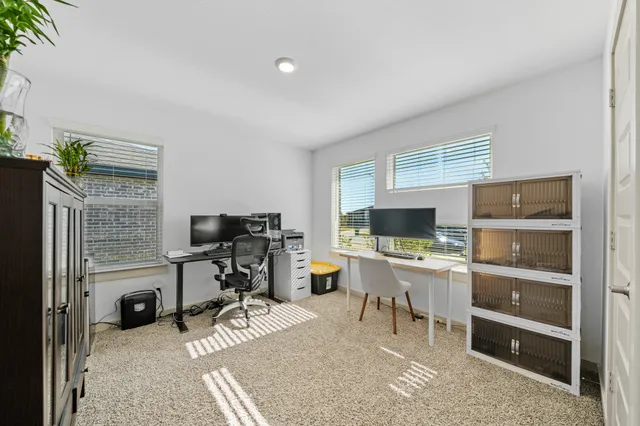 a view of a workspace with furniture and a window
