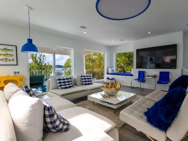 a living room with furniture a flat screen tv and a large window