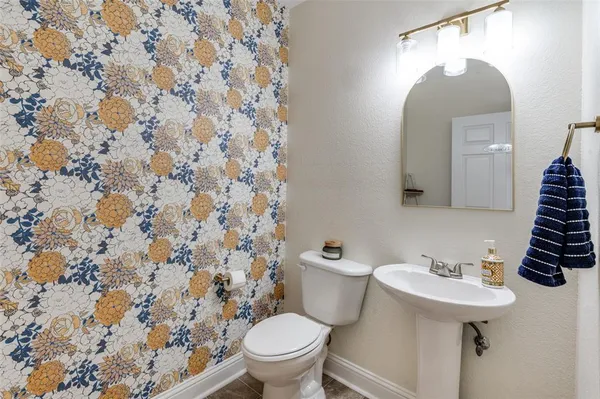 a bathroom with a sink toilet and a mirror