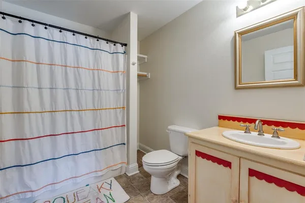 a bathroom with a sink a toilet and shower curtain
