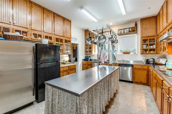 a kitchen with stainless steel appliances granite countertop a refrigerator a sink and a stove