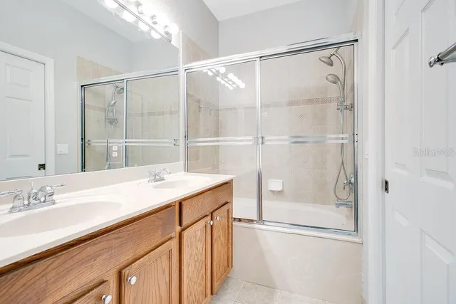 a bathroom with a shower sink vanity and mirror