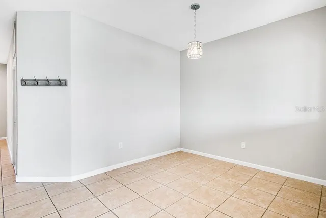 an empty room with chandelier fan