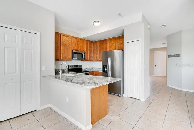 a kitchen with stainless steel appliances granite countertop a refrigerator stove and a sink