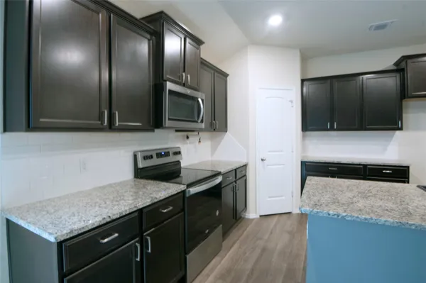 a kitchen with granite countertop stainless steel appliances and wooden cabinets