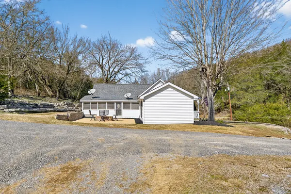 a view of a house with backyard and trees