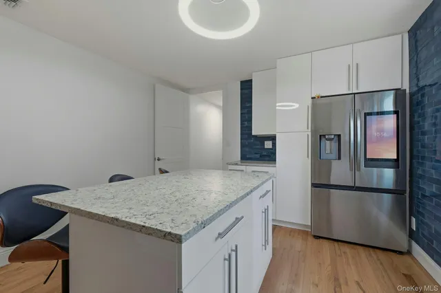 a kitchen with stainless steel appliances granite countertop a refrigerator a sink and a stove