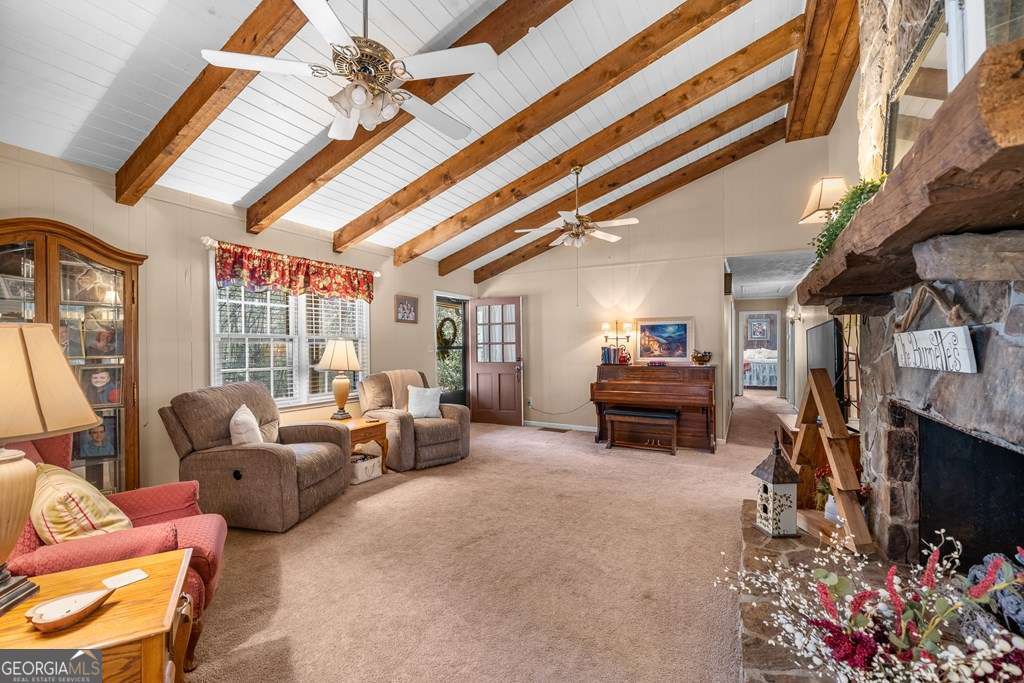 2164 Yukon Road Ellijay, GA 30536 - Photo 23 of 43 a living room with furniture a fireplace and a chandelier