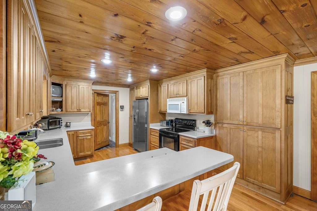 2164 Yukon Road Ellijay, GA 30536 - Photo 28 of 43 a kitchen with sink a refrigerator and chairs