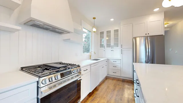 a kitchen with white cabinets and appliances