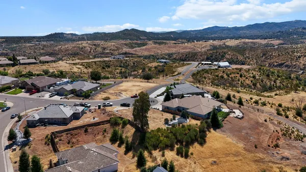 an aerial view of residential houses with outdoor space and mountain view