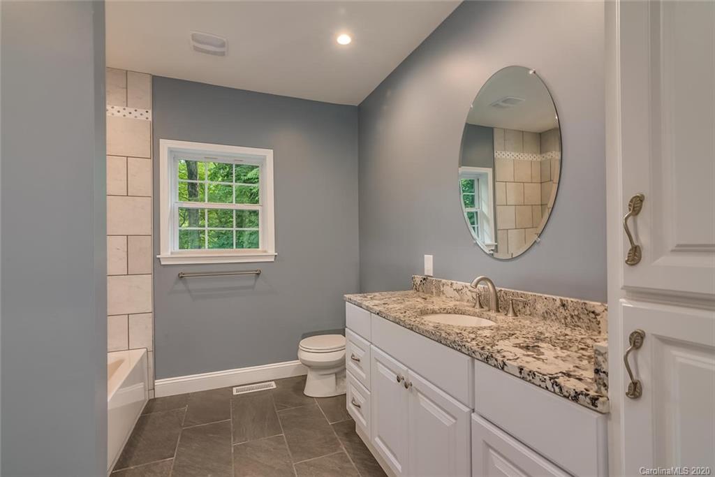 603 Vineyard Road Tryon, NC 28782 - Photo 28 of 39 a bathroom with a granite countertop sink a toilet and a mirror