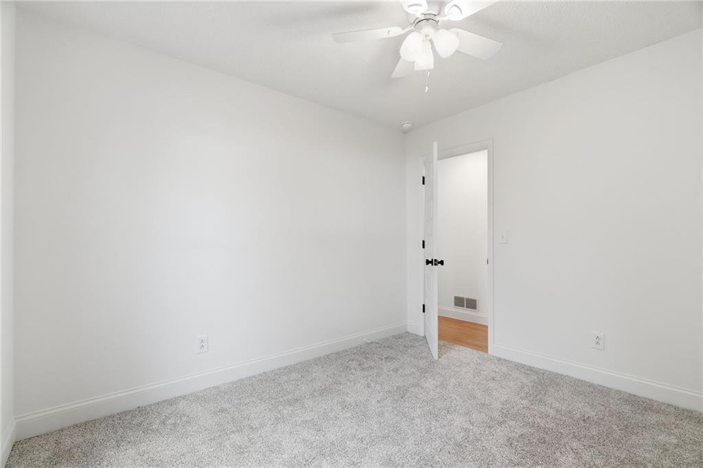 3447 Dry Creek Road Marietta, GA 30062 - Photo 21 of 42 an empty room with a white walls and chandelier fan