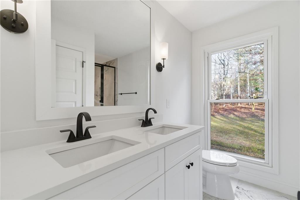 3447 Dry Creek Road Marietta, GA 30062 - Photo 30 of 42 a bathroom with a sink a toilet and a mirror