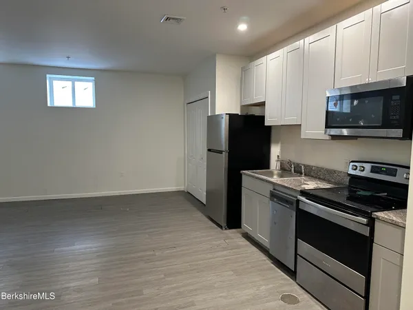 a kitchen with a refrigerator stove and white cabinets