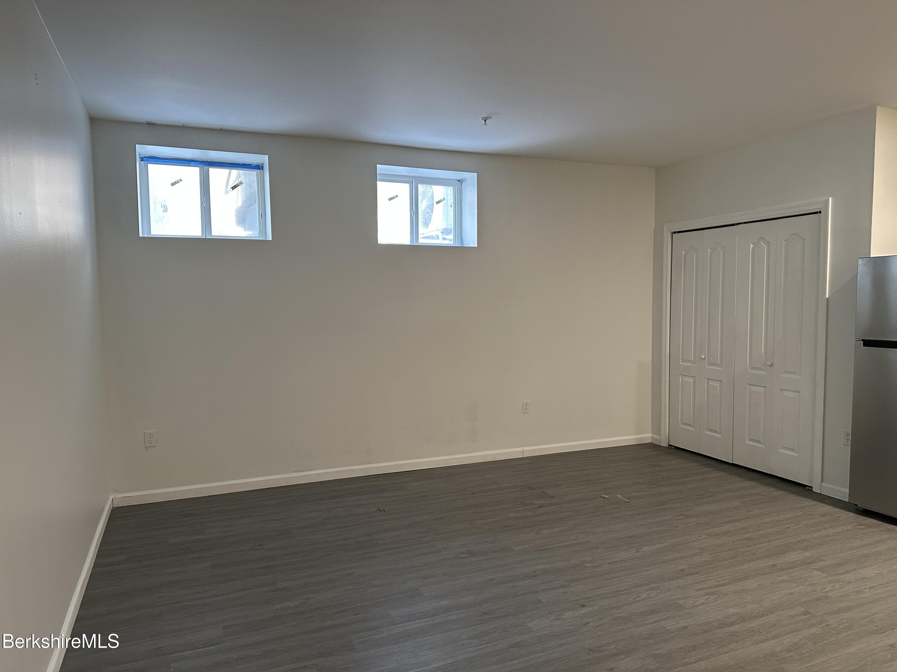 235 East Street, Unit 26 Pittsfield, MA 01201 - Photo 2 of 7 a view of an empty room with wooden floor and a window