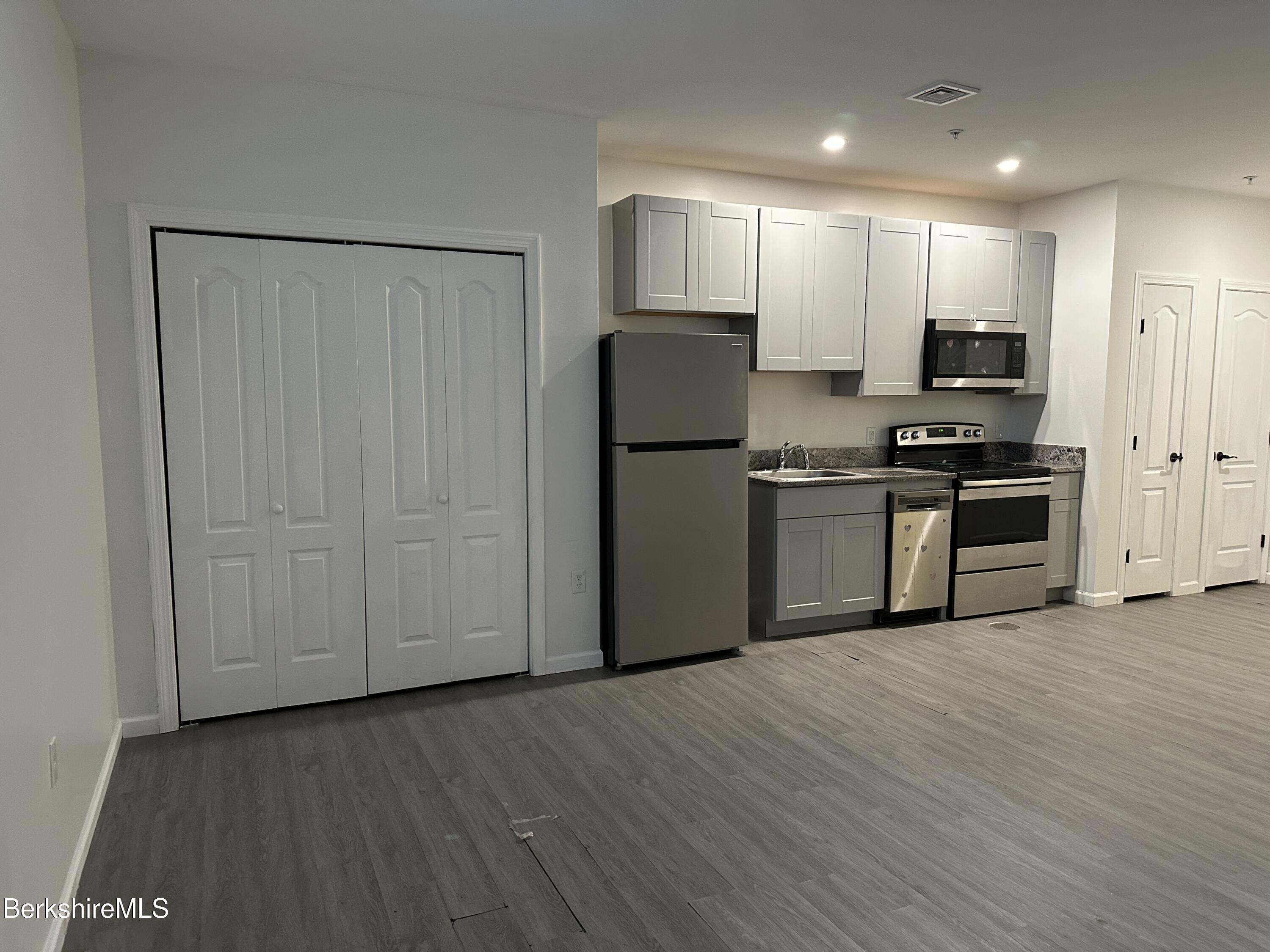 235 East Street, Unit 26 Pittsfield, MA 01201 - Photo 5 of 7 a kitchen with wooden cabinets and stainless steel appliances