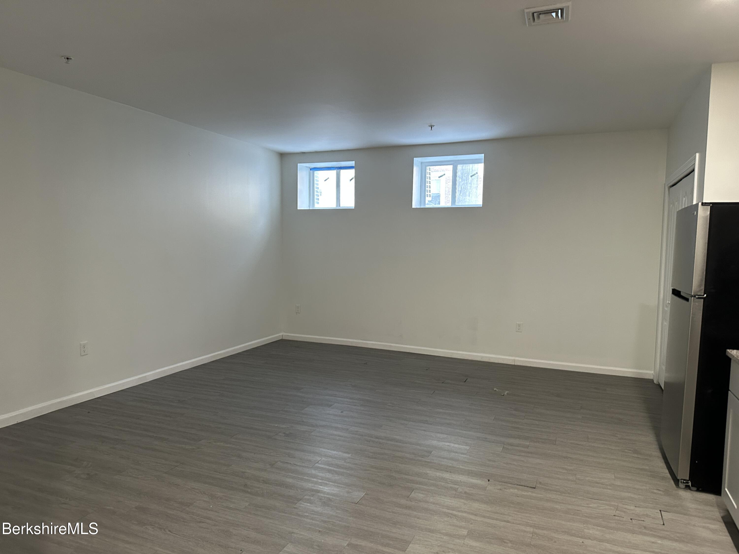 235 East Street, Unit 26 Pittsfield, MA 01201 - Photo 6 of 7 a view of an empty room with wooden floor and a window